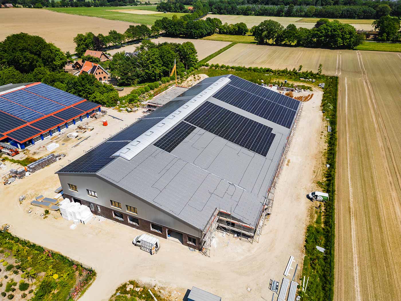 Luftaufnahme einer Halle mit PV-Anlage in Bornhorn